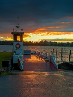 Sunset over the Chiemsee, in front the Chiemsee ferry, view from the island Frauenchiemsee,