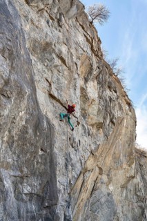 Climber climbs on a rocky wall. Extreme sport climbing