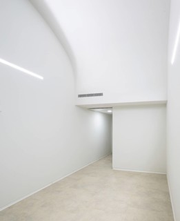 Minimalistic hallway of hospital featuring sleek white walls, soft ambient lighting, and a curved