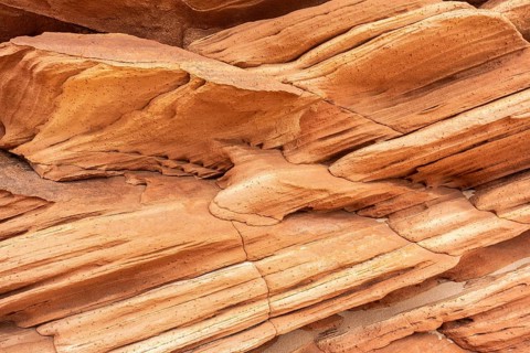Close-up of sandstone showcasing intricate natural textures and abstract patterns in earthy hues,