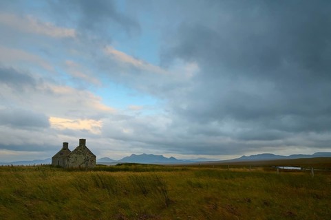 Stone house in a vast landscape at dusk under a cloudy sky, Moine House, Lairg, Scotland, United