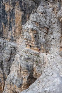 Three hikers on the Via Ferrate Benini via ferrata on a cliff, Brenta Mountains, Parco Naturale