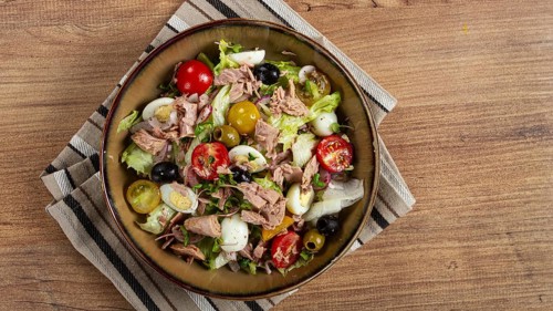Salad with canned tuna, vegetable salad with quail eggs, lettuce, red onion, cherry tomatoes,
