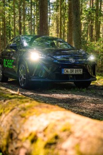 Black car with shining headlights on a forest path, Deer E- Carsharing, Calw, Black Forest, Germany
