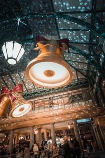 Large Christmas bells and lights project patterns onto the walls in a festive shopping mall,