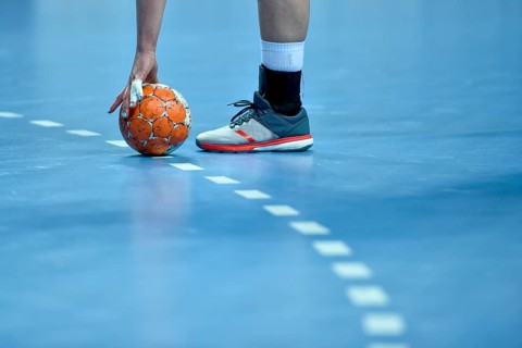 Handball players takes ball from the parquet in Lubin, Poland