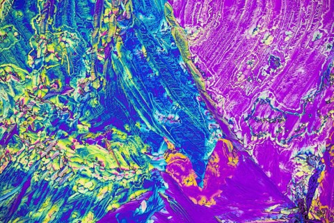 A stunning microscopic view of microcrystals showcasing a vivid array of colors including blue,