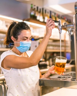 Photo session with a waitress with a face mask in a bar. New normality, security measures after the