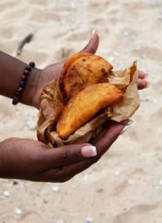 Women's hands holding samoussas or deep-fried dumplings, Mauritius
