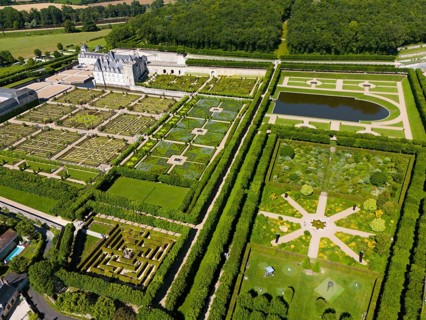 Overview of a castle with symmetrical, artistically designed gardens and parkland, aerial view,