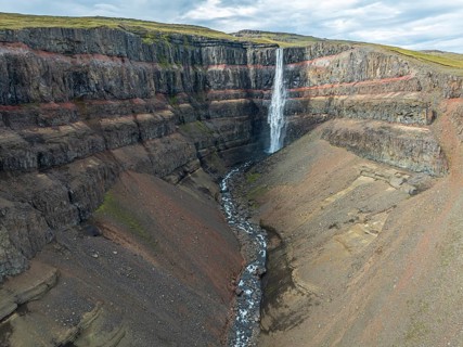 Waterfall Hengifoss, basaltic layers interwoven with red sedimentary layers, aerial view, Iceland