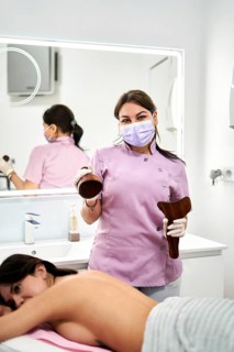 Expert therapist performs a massage treatment in a modern aesthetic medicine clinic. The calming