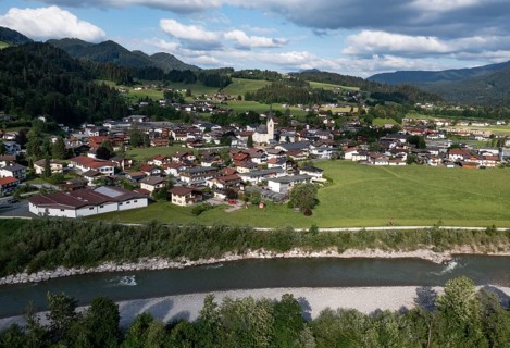 Drone shot, view of the village with parish church, Kössen, Leukental, Tyrol, Austria