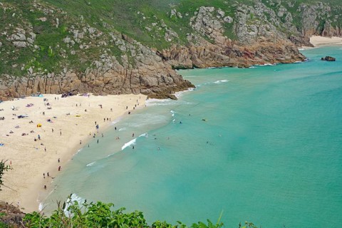 Wunderschöner Sandstrand an türkisfarbenem Meer mit umgebenden Klippen, Porthcurno, St Levan,