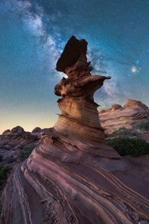 A stunning rock formation stands beneath a starry sky, showcasing the Milky Way in vivid detail.