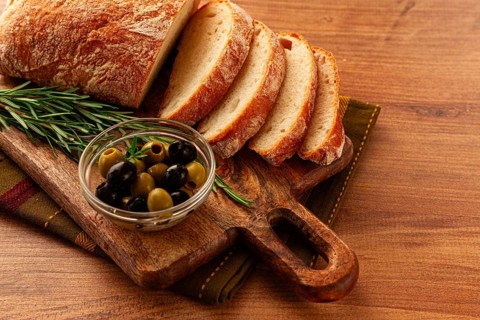 Sliced ciabatta, on a chopping board, with rosemary and olives, Italian bread, close-up, Italian