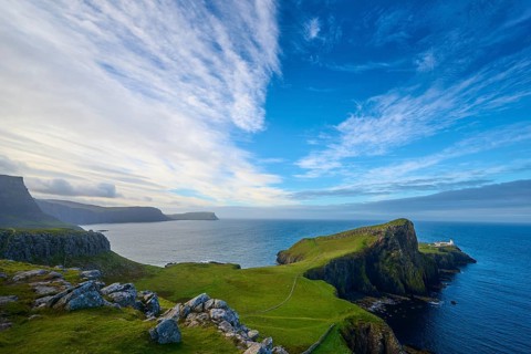 Wide angle view of a coastal landscape with cliffs under a dramatic sky, Neist Point Lighthouse,