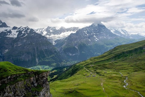 View of mountain landscape with green meadows and alpine huts Bachlager, Grindelwald First,