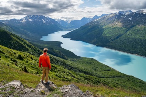Mountaineer enjoys views of blue lake and mountains on Twin Peaks Trail, Eklutna Lake, Chugach