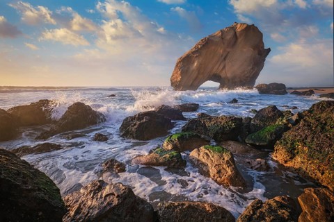 Penedo do Guincho stands majestically at Praia da Santa Cruz, with waves crashing and a stunning