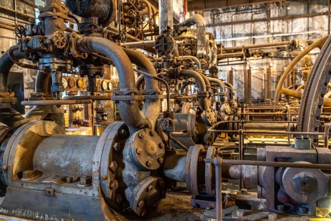 Historic industrial plant with rusted pipes, valves and machines, interior of the former meat