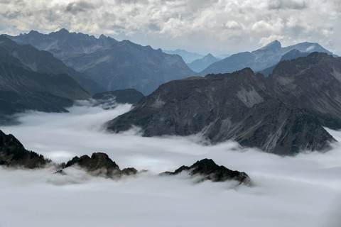 View from the Nebelhorn summit to mountains of the Allgäu Alps, mountains rising from fog in the