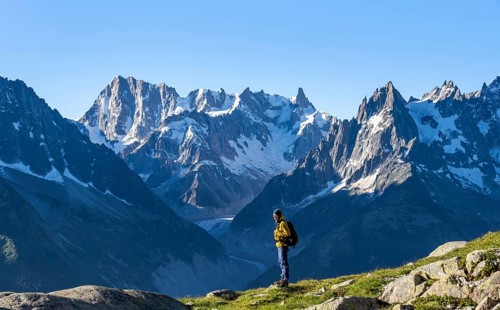 Young man in front of impressive mountain landscape in morning light, picturesque mountain