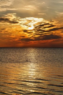 Sunlight glitters golden on the Baltic Sea, evening sky at sunset, Burgsvik, Gotland Island, Sweden