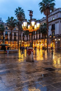 Nightlife at Plaça Reial, lanterns by Gaudi in the historic centre of Barcelona, Spain