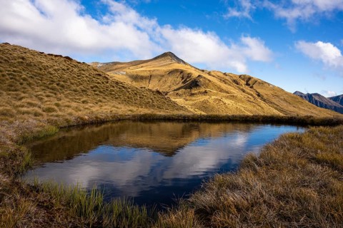 Mountain landscape with a small lake. Mount Burns, Borland Road Area, Fiordland National Park,