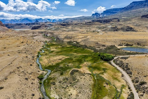 Gravel road ruta 41, Los Antiguos - Paso Roballo, stretch of green along river Columna, aerial