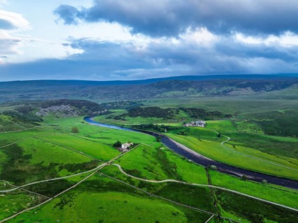 Forest in Teesdale over River Tees from a drone, North Pennines AONB, County Durham, England,
