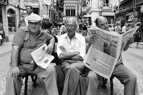 Three men sitting on a bench in the historic city center of Lisbon, Lisbon, Portugal
