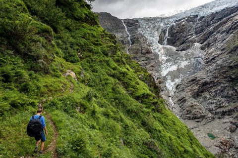 Mountaineers on a hiking trail, cloudy mountain landscape with Grindelwald-Fiescherfirn glacier,