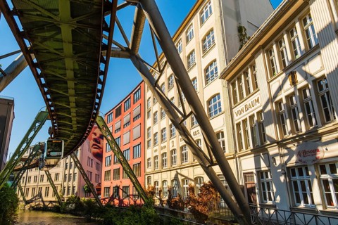 A suspension railway runs between old industrial buildings near the Kluse stop, Wuppertal, Germany