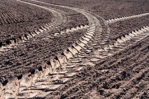 Tractor tracks, agricultural trails at a cultivated field in springtime, farmland near Wesertal,