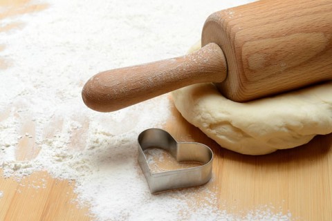 Dough roller on dough and cookie cutter, cake dough