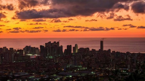 Skyline at sunset with illuminated buildings and deep red sky, Batumi, Georgia