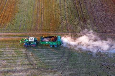 Tractor with manure spreader, agricultural machine used to distribute manure over a field as