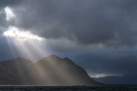 Sunbeams over coastal landscape and sea, Lofoten, Nordland, Norway, September 2020