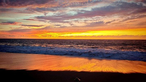 Romantic sunset on the beach, the sea reflecting the warm tones of the evening sky, Tarrafal de