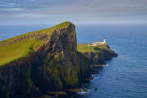 Close-up of a lighthouse on a green cliff surrounded by blue sea, Neist Point Lighthouse,