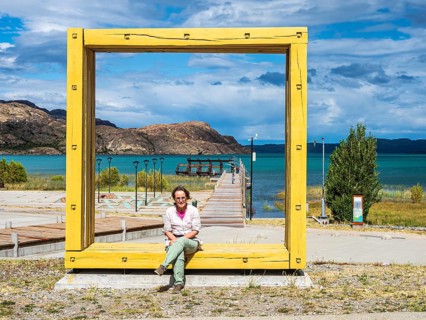 Woman sitting in an oversized frame, art object, pier at Puerto Ingeniero Ibanez, lake Lago General