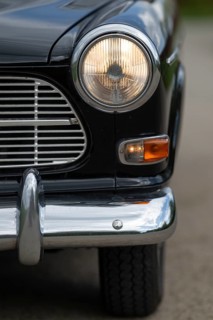 Front round front light and front section with chrome bumper, vintage car, black Volvo Amazon,