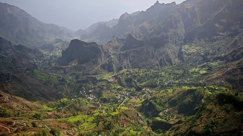Panoramic, spectacular view over a valley with a winding path, hiking trail and mountains in the