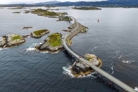 Aerial view of the Atlantic Ocean Road (Atlanterhavsveien), red sailing boat, Norway