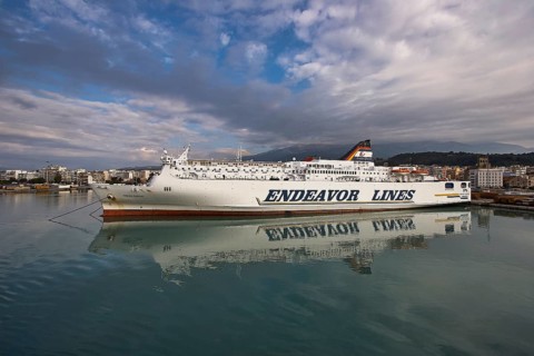 Ferry in port with urban background and reflecting water, Old ferry port in central Patras,