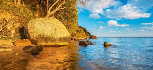 Coastal landscape with large boulders on the Baltic Sea beach in the evening light, Mönchgut Nature