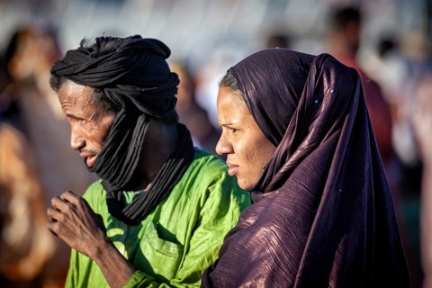 A man and a woman in traditional dress stand in the open air, a couple at the traditional Tuareg