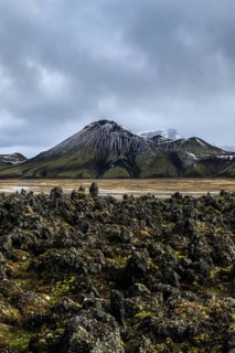 Rugged Icelandic Highlands showcase a majestic mountain under dramatic skies, surrounded by